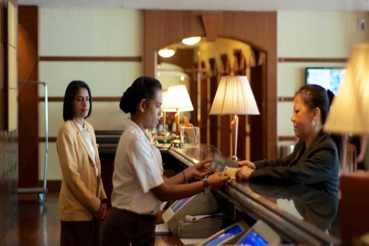 ذا جورني ريزورت هوتيل آند ريزيدنسز جورج تاون المظهر الخارجي الصورة A hotel receptionist at work